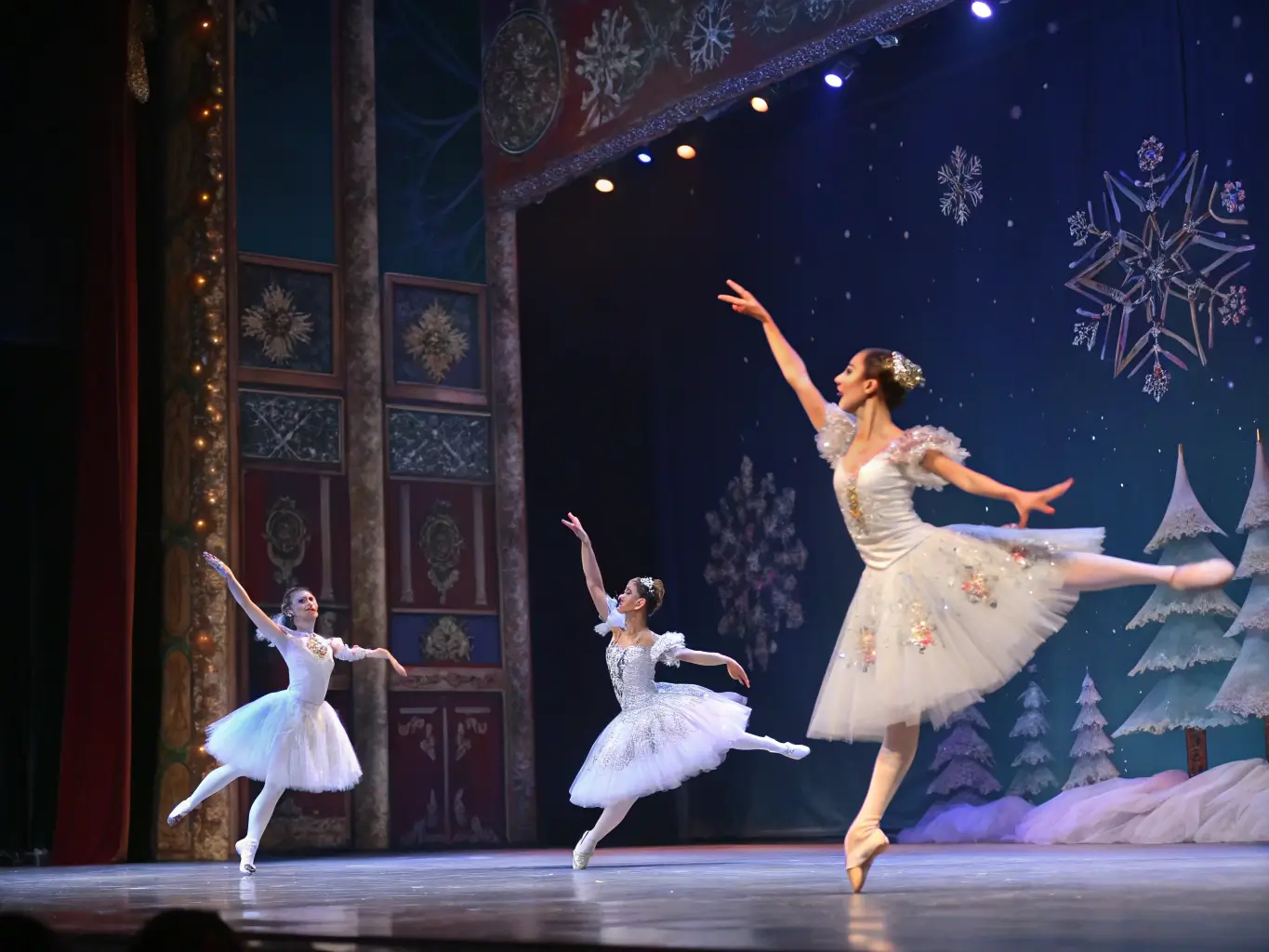 Dancers performing The Nutcracker ballet in a magical winter scene under dramatic stage lighting