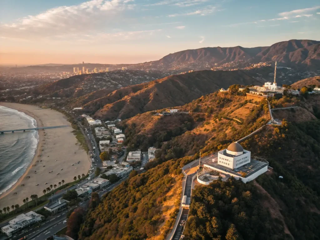 "Aerial view of Los Angeles at sunset showcasing the Hollywood Sign, Santa Monica Pier, Getty Center, Griffith Observatory, and downtown skyline framed by palm-lined streets"
