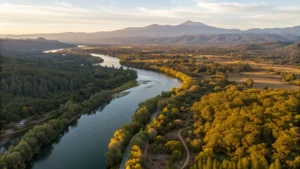 "Aerial view of Redding, California showing the Sacramento River, Whiskeytown National Recreation Area, fields of sunflowers and zinnias, Shasta Lake, Mount Shasta, hikers on trails, and golden hour lighting in September"