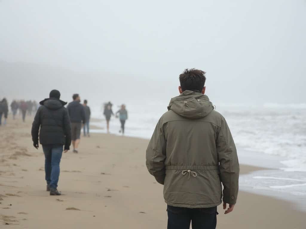 Visitors in layered clothing strolling on Pismo Beach during the nuanced weather of Central Coast's shoulder season