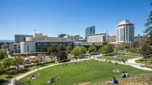 "Panoramic view of downtown San Jose on a sunny day with Discovery Meadow park, Museum of Art, Tech Innovation Center, Japanese Friendship Garden, and a local farmers market under clear skies and golden hour sunlight."