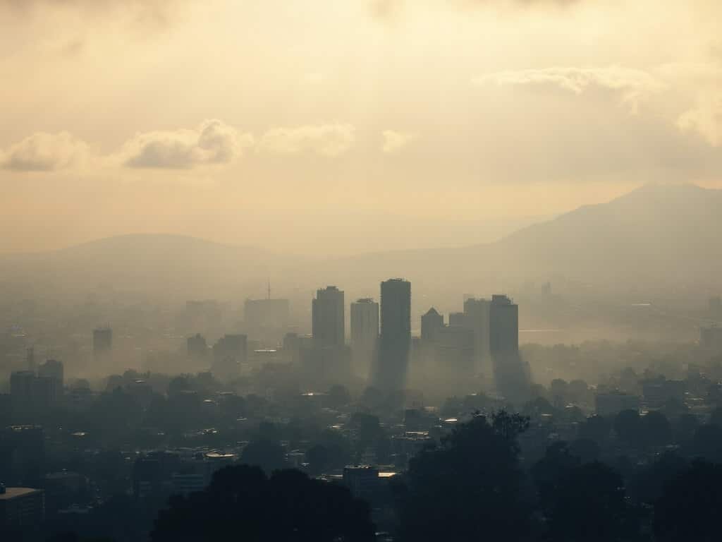 Misty morning cityscape of San Jose with golden light filtering through clouds, mountains in the background